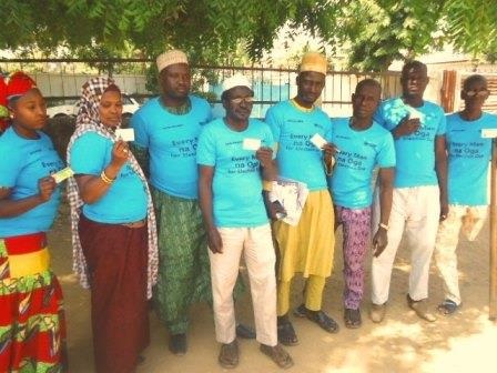 community facilitators displaying their voters card during orientation meeting